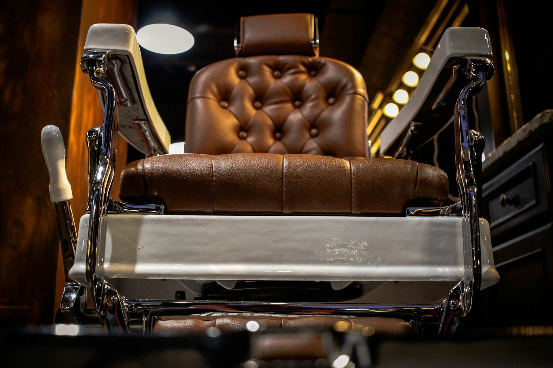 A worn leather barber's chair waiting for the next booking.