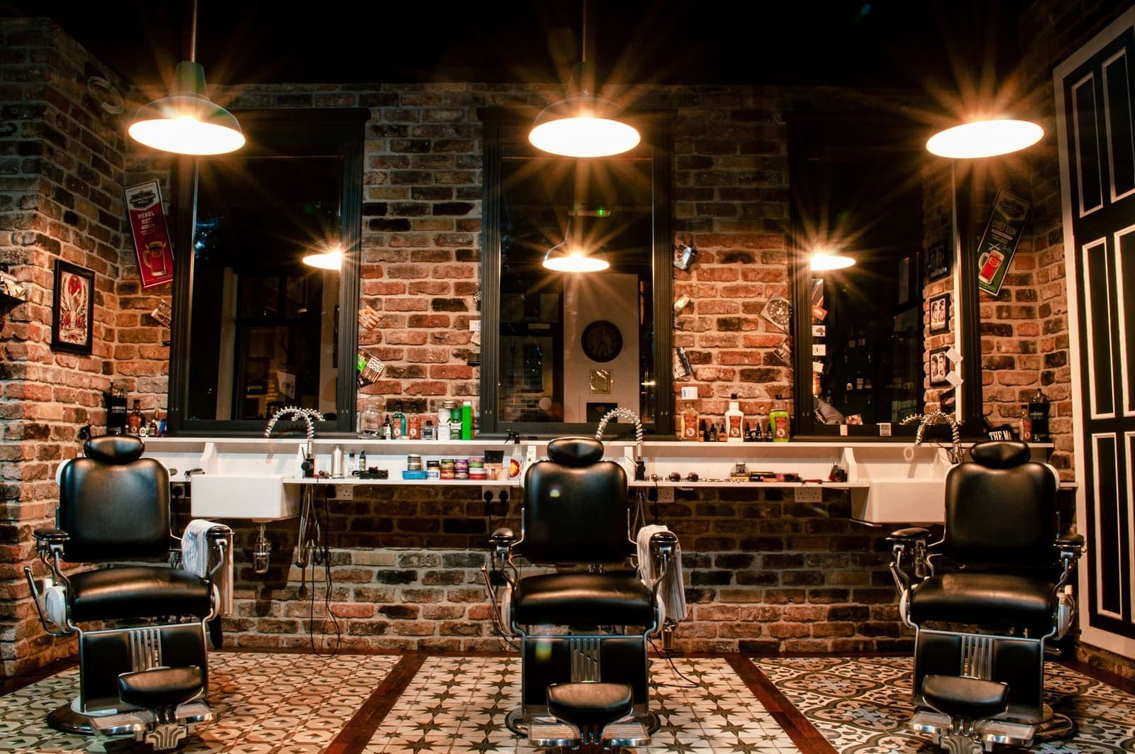 Leather chairs and warm lamps in a brick-walled barbershop.