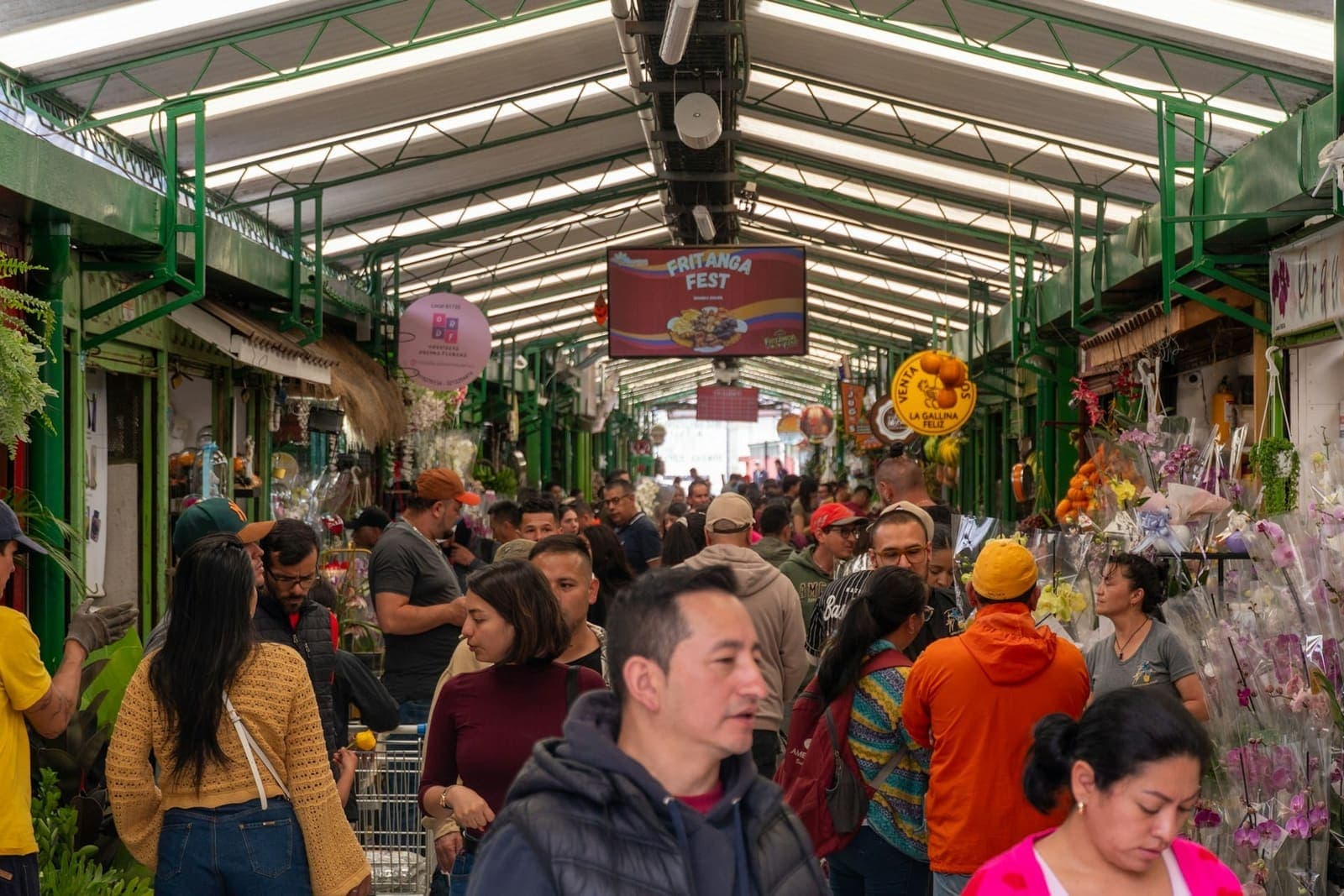 Shoppers weaving between the stalls of a covered market.